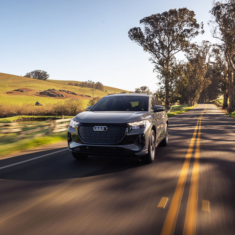 Three-quarter front view of the Audi Q4 e-tron making a turn. 