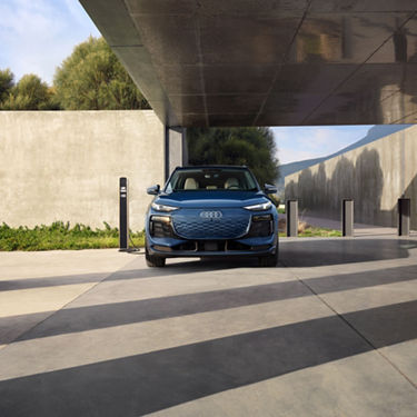 Front profile of the Audi Q6 e-tron parked and charging.