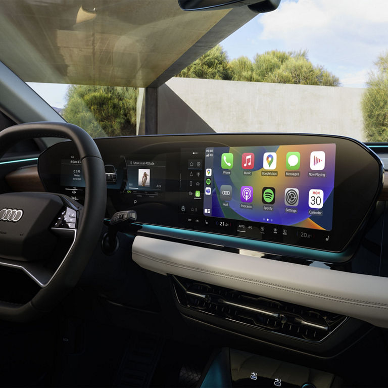 Interior view of the Audi Q6 e-tron dashboard including virtual cockpit, MMI touch display, and passenger side display.  