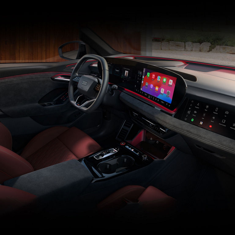 Interior view of the Audi Q6 e-tron dashboard including virtual cockpit, MMI touch display, and passenger side display.  