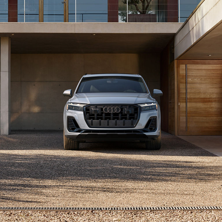Side profile of a red Audi Q7 parked.