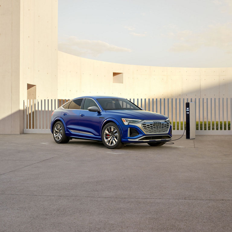 Three-quarter side view of the Audi SQ8 Sportback e-tron parked and charging.