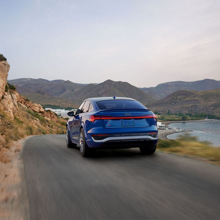 Rear view of the Audi SQ8 Sportback e-tron accelerating on a mountain road.