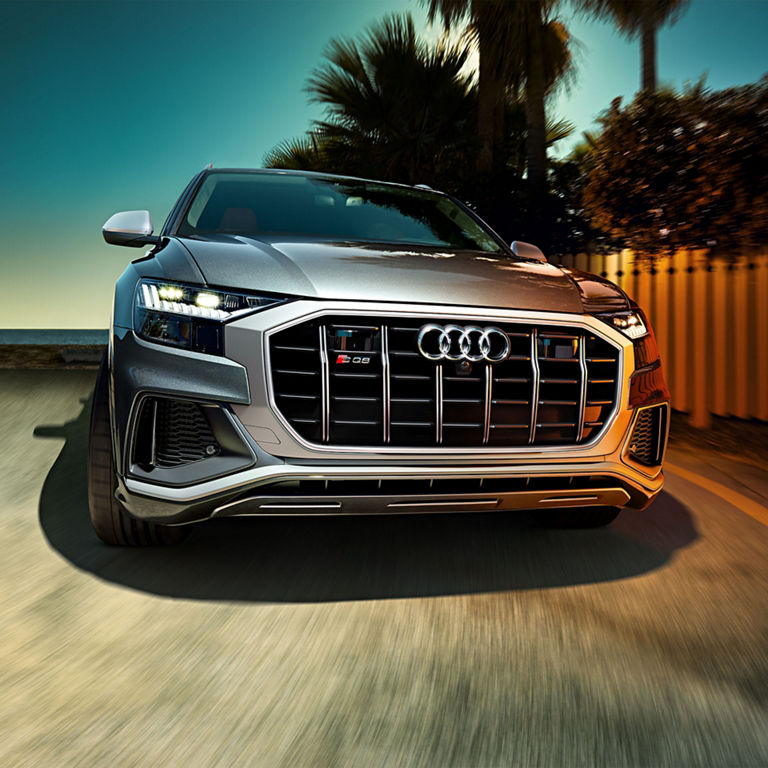 Side view of the Audi SQ8 with a person walking beside it.