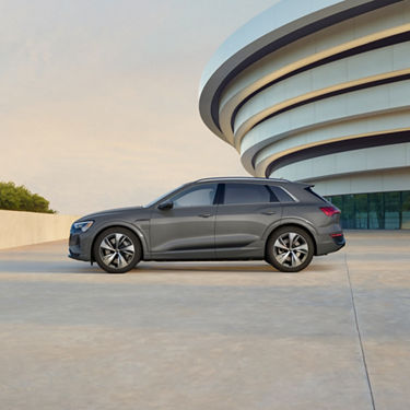 Side profile of a gray Audi Q8 e-tron parked.