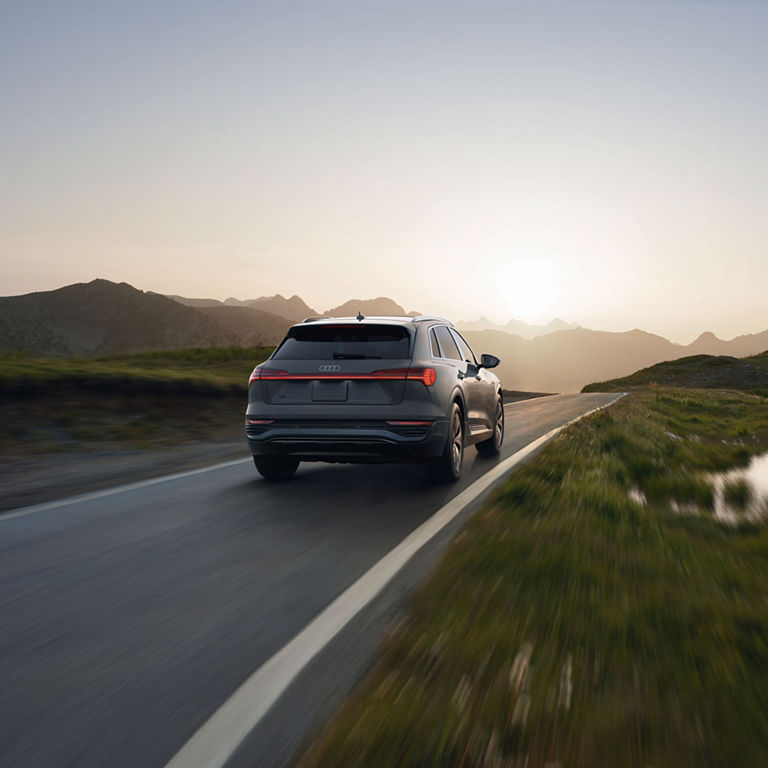 Rear profile of a gray Audi Q8 e-tron accelerating.
