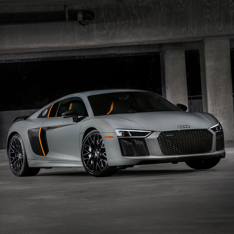 Low-angle shot of a silver Audi R8 in a parking garage, showcasing the Audi laser light. 