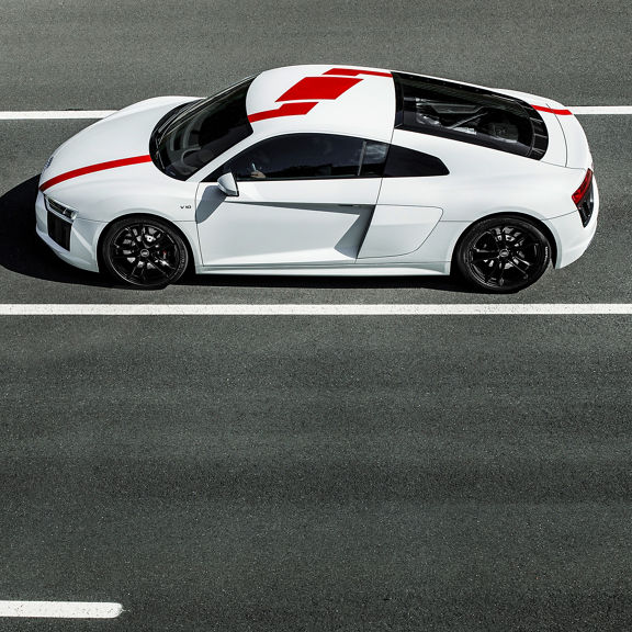 Side profile of a white Audi R8 RWS with red racing stripes.