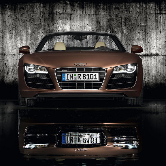 Close-up of the grille and full-LED headlights of a brown Audi R8.