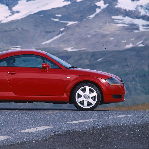 Side view of a red Audi TT Coupe parked on the road.