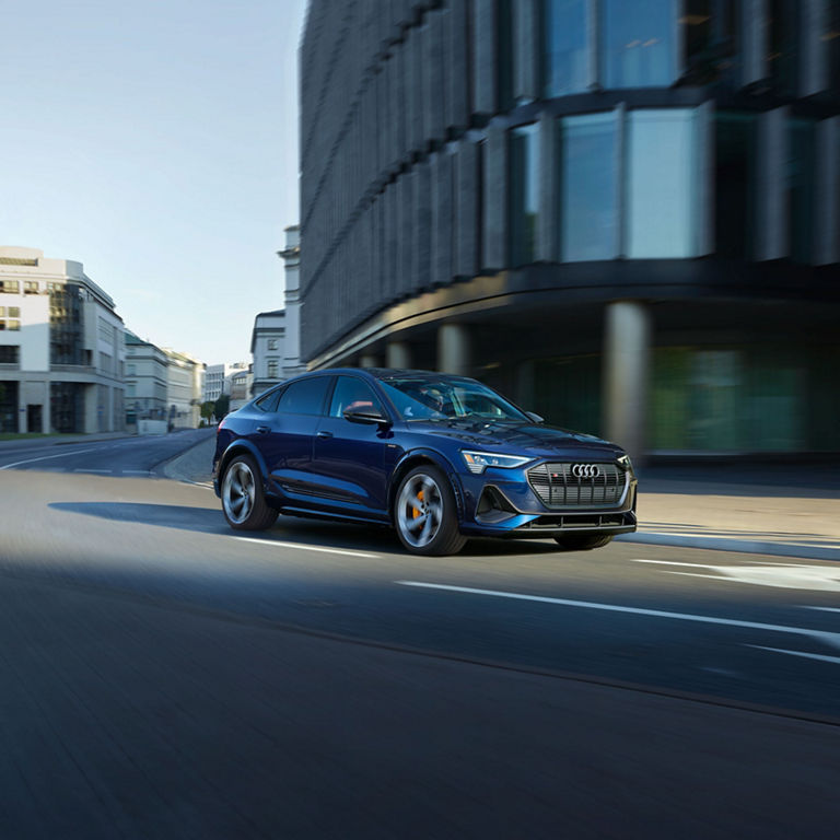 Three-quarter front profile of the Audi e-tron® S Sportback accelerating.