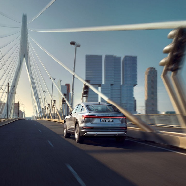 Three-quarter rear profile of the Audi e-tron® Sportback accelerating.