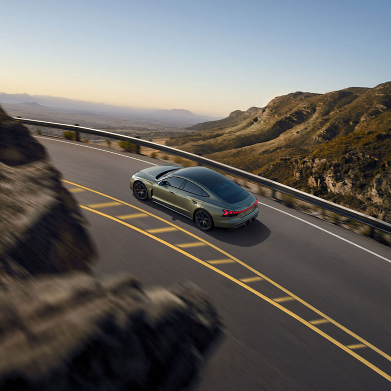 Rear aerial view of the Audi RS e-tron GT in motion. 