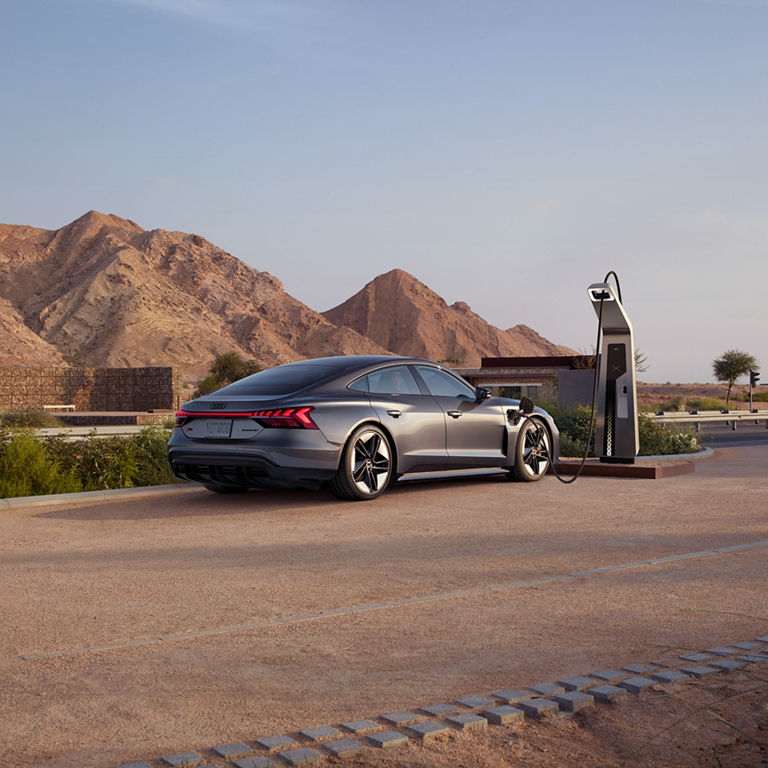 Plan large de l’arrière d’une Audi e-tron GT stationnée dans une entrée résidentielle. 