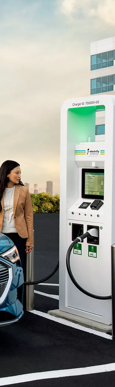 A person charging the Audi e-tron® at an Electrify America charging station.