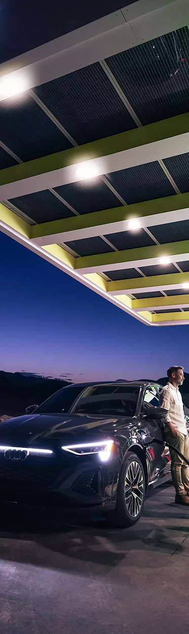 A person charging the Audi e-tron® at an Electrify America charging station.