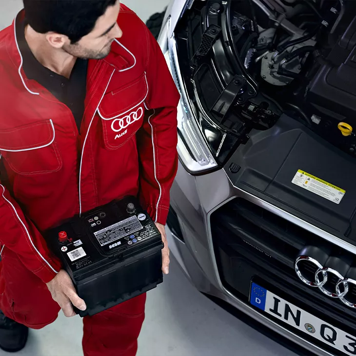 An Audi mechanic working on a vehicle. 