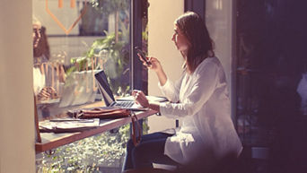 A woman sitting in a café on her phone. 