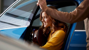 A woman exiting her blue Audi. 