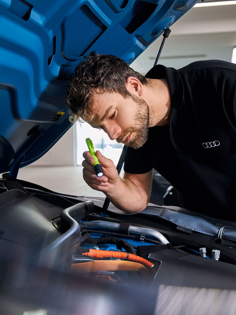 An Audi technician servicing a vehicle.