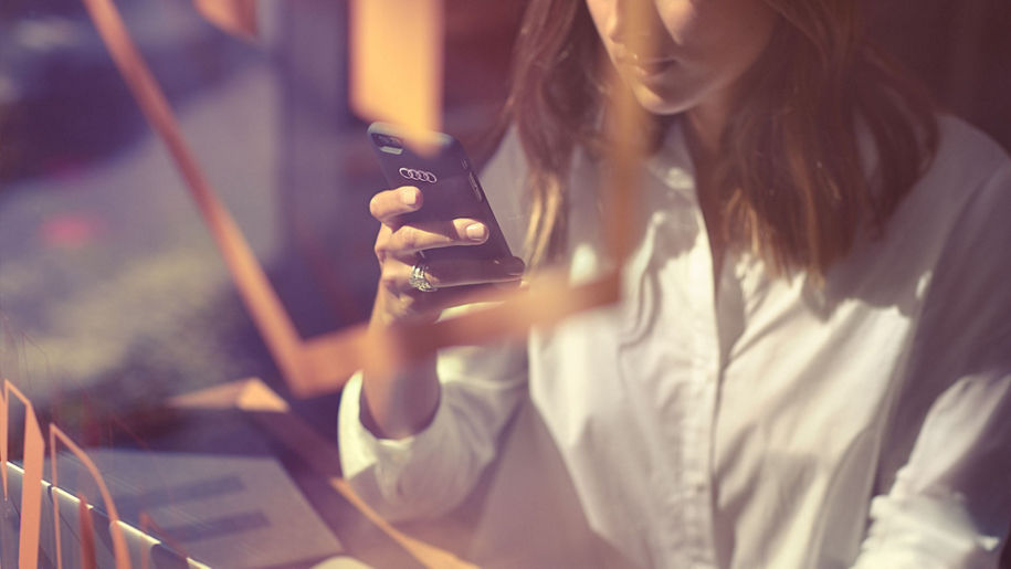 An Audi owner using the myAudi app on their smartphone.