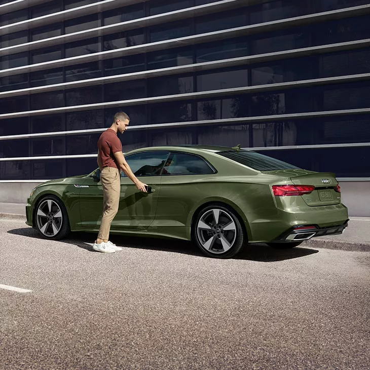 A man opening the door of an Audi A5 Coupe.