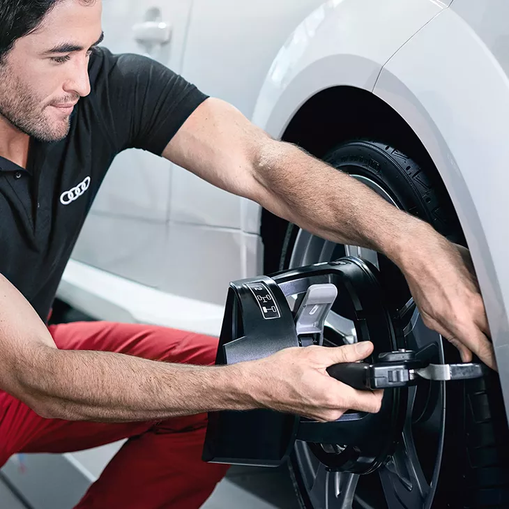 An Audi technician servicing a vehicle.