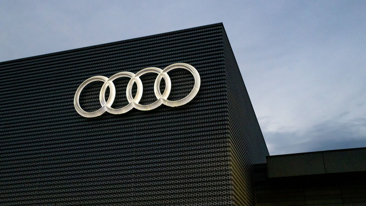 Close up on the Audi rings on the exterior of an Audi dealership.