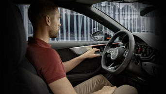 Interior view of a man driving an Audi. 