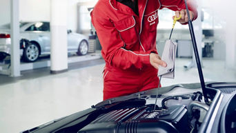 An Audi technician perforning an oil change. 