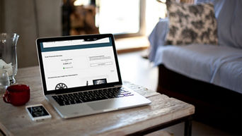 A laptop on a coffee table open to the myAudi portal. 