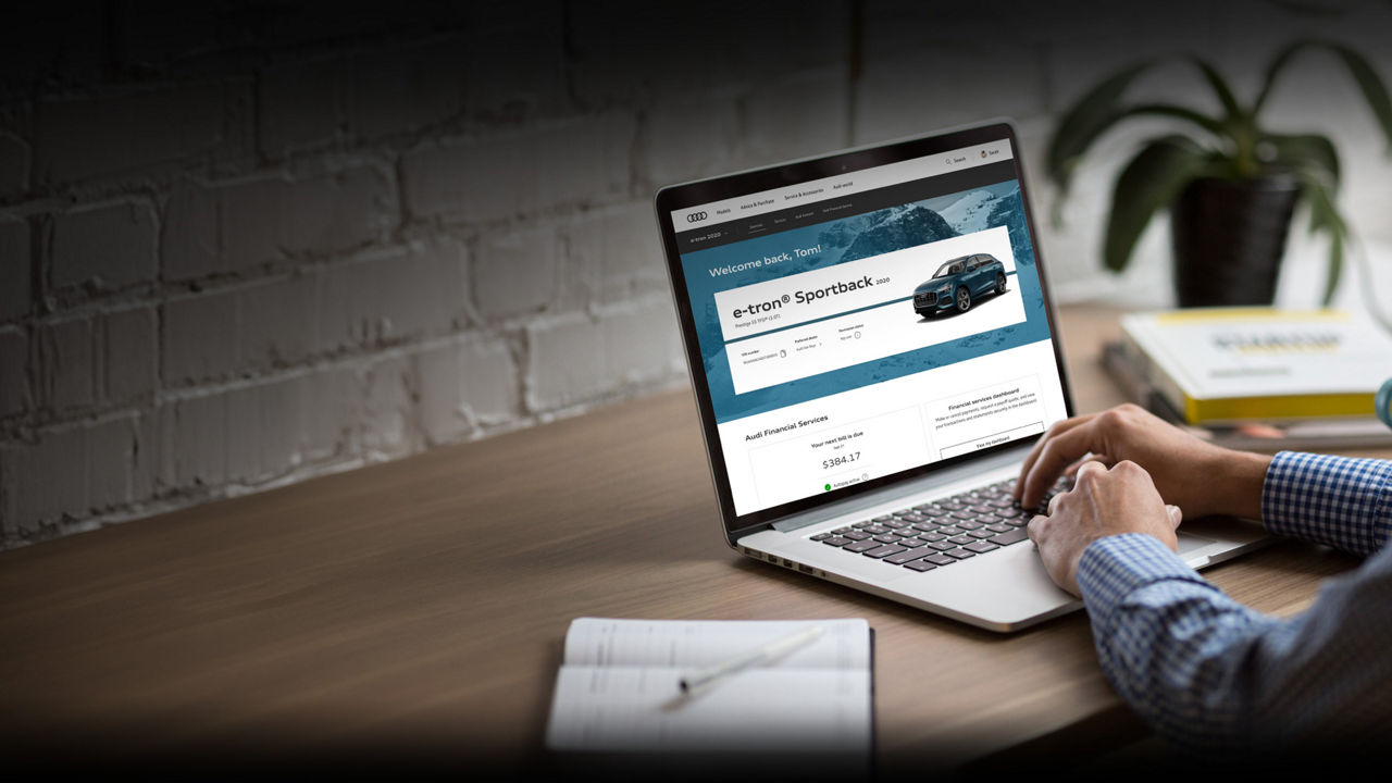 A man browsing his myAudi dashboard on a laptop.