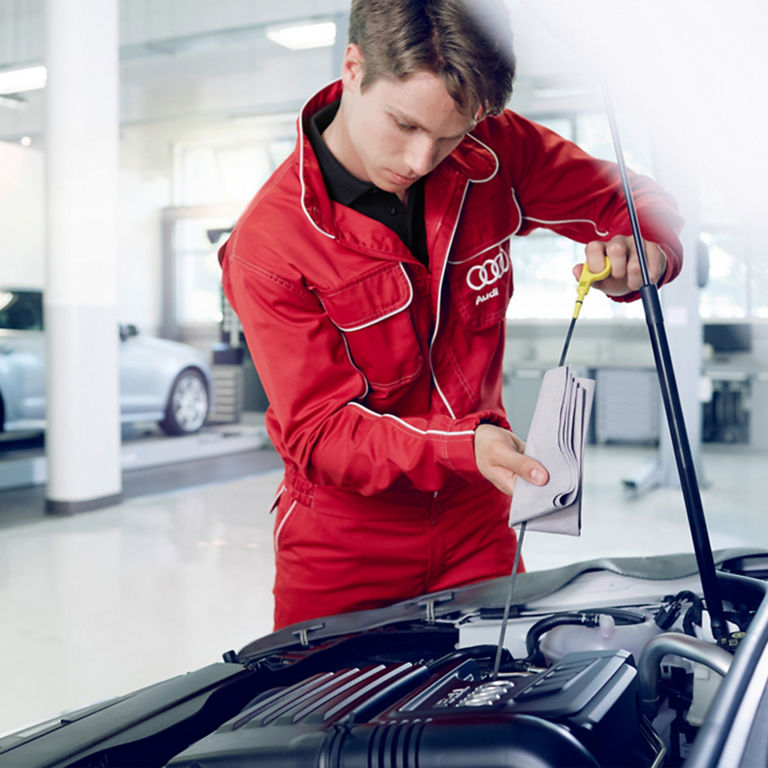 An Audi technician perforning an oil change. 