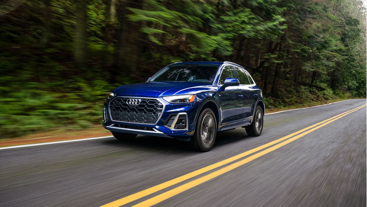 Photo of an Audi e-tron SUV parked near a wall.