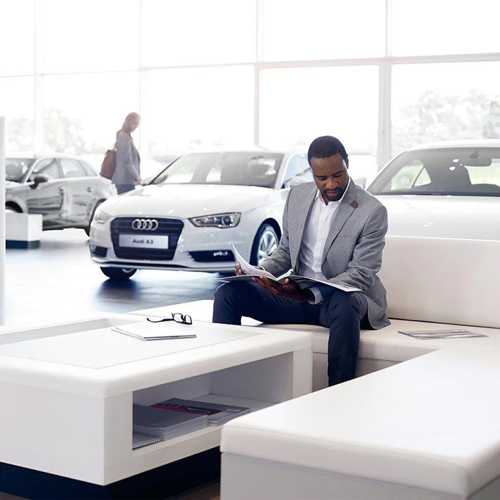 A person sitting at an Audi dealership.