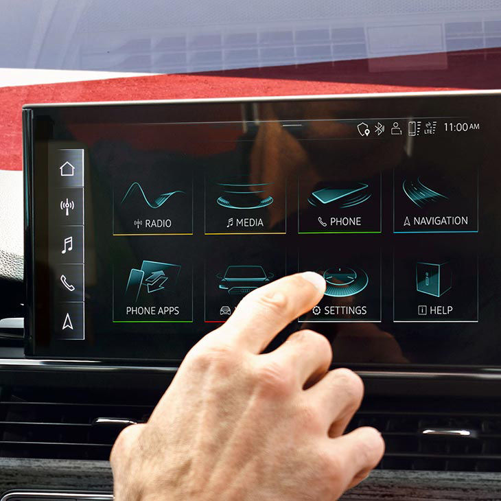 A close-up photo of the Audi MMI technology display embedded in the dashboard of an Audi vehicle.