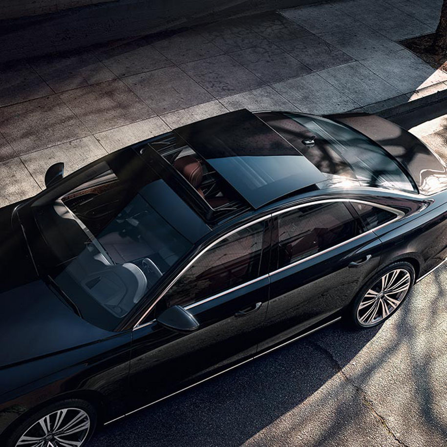 An aerial photo of a parked Audi vehicle with its sunroof partially open.