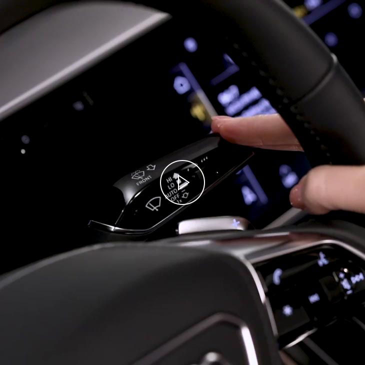 A close-up photo inside an Audi vehicle showing the windshield wipers button.