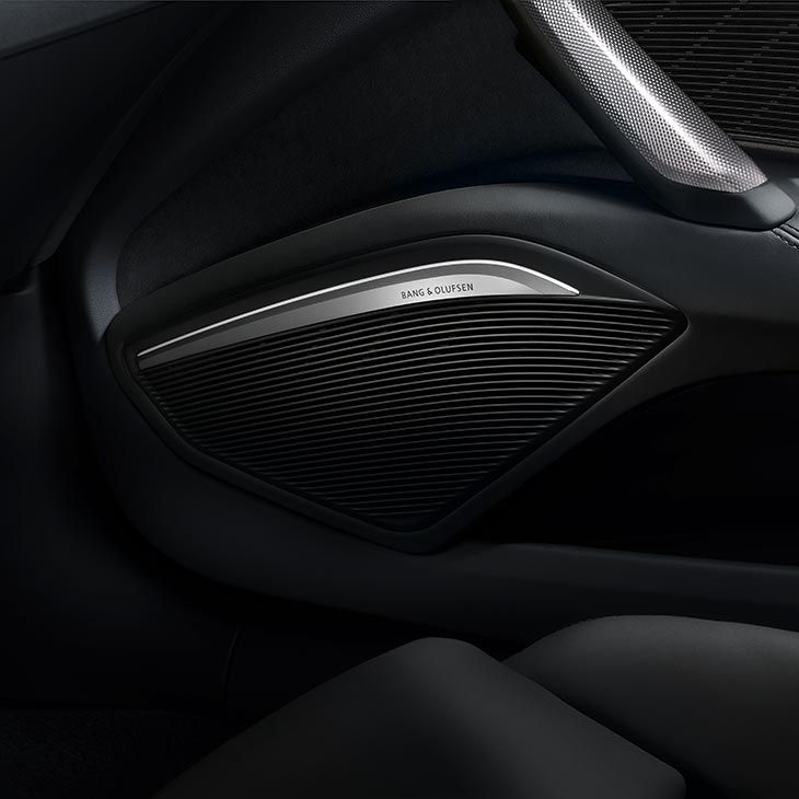 A close-up photo of a Bang & Olufsen speaker inside an Audi vehicle.