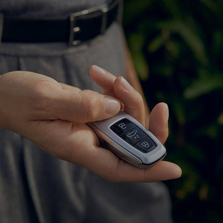 A close-up photo of someone's hand holding an Audi key fob.
