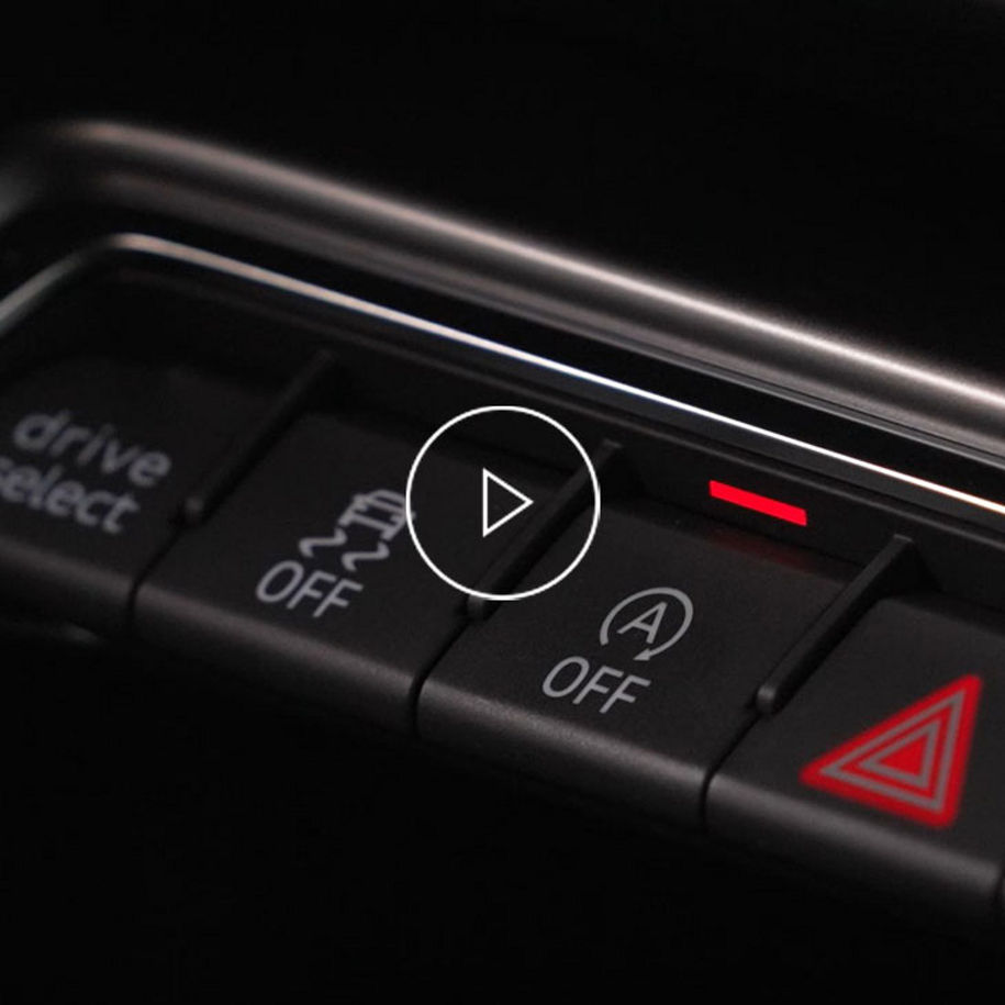 Close-up on the start/ stop system button inside an Audi vehicle.