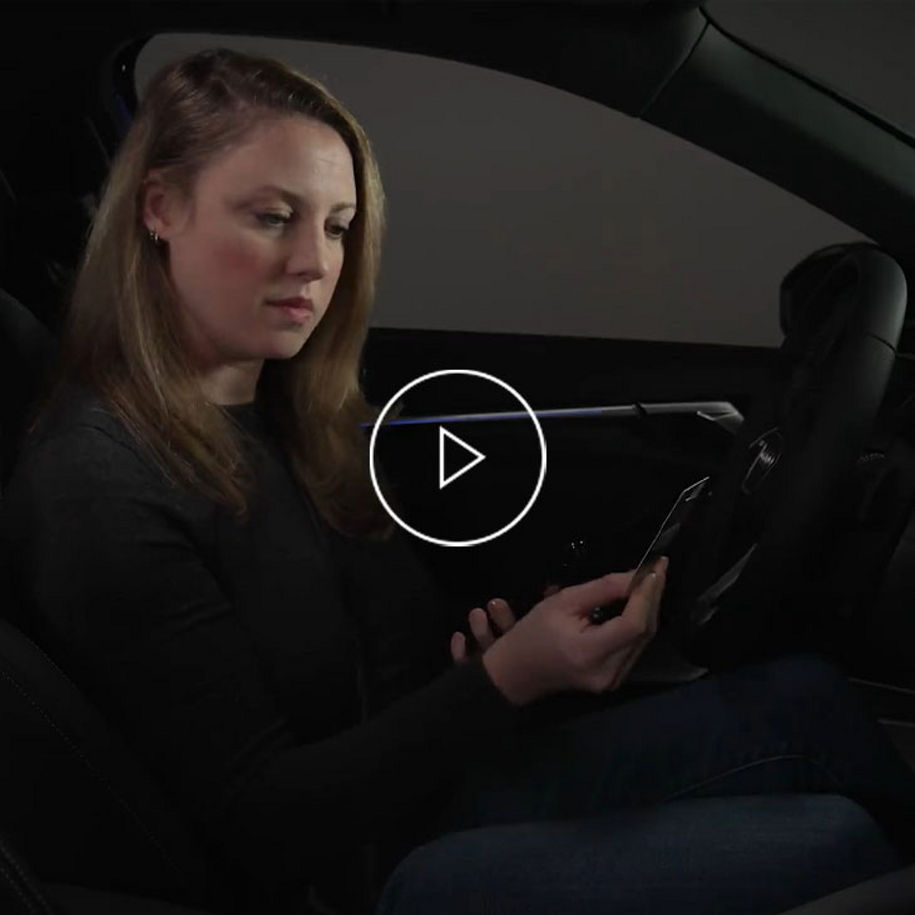 Close-up of a woman on a mobile phone sitting in her Audi vehicle. 