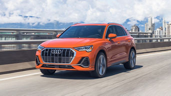 Front view of an Audi vehicle accelerating on a highway.