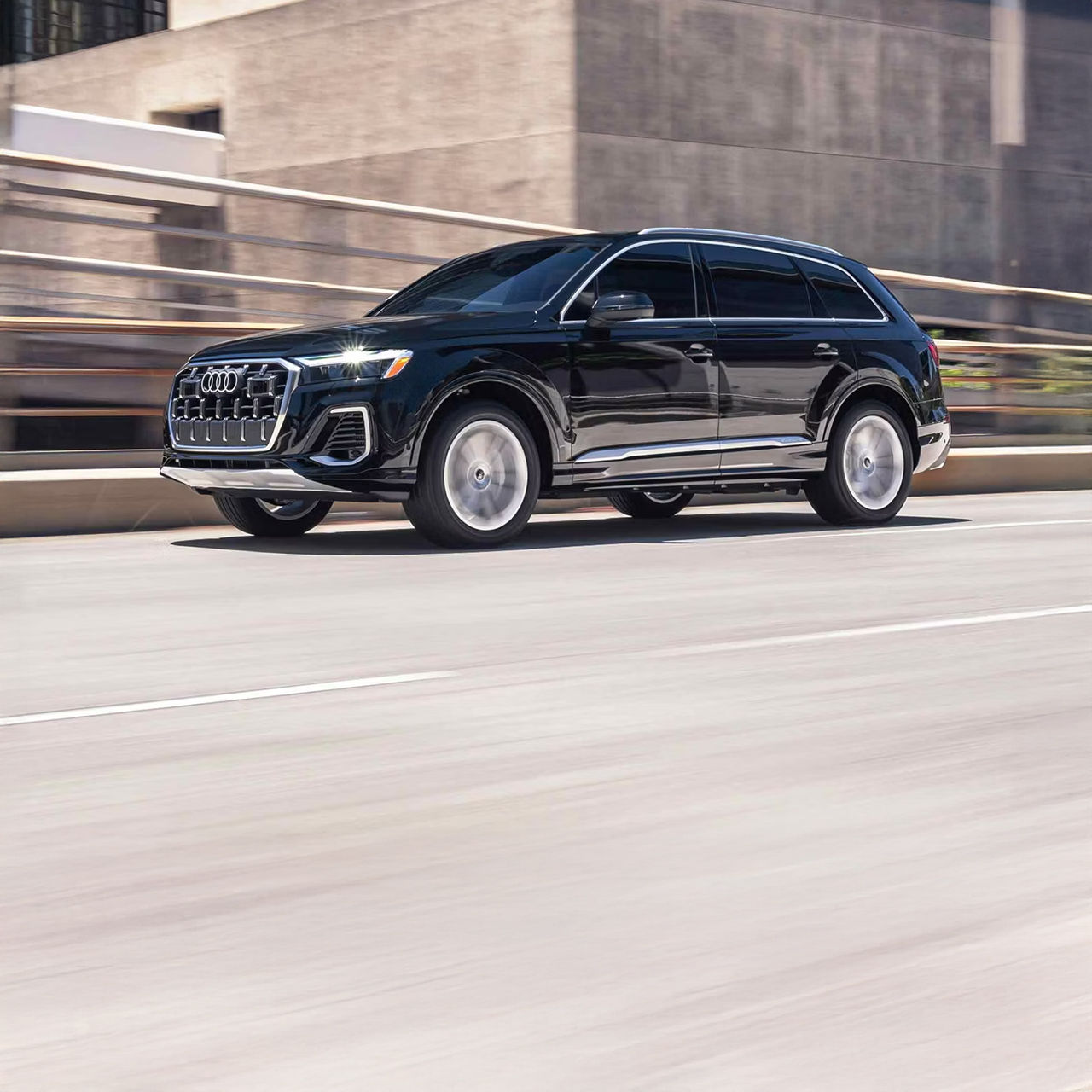 Left profile view of an Audi Q7 accelerating.