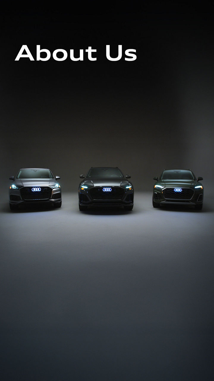 Three Audi cars parked side by side in a showroom-style garage
