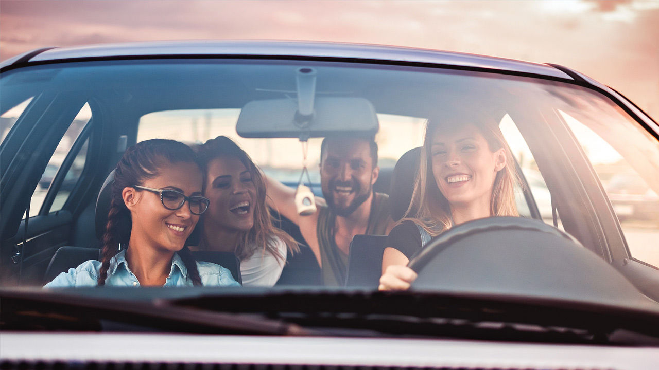 Two people chatting with each other across the gas pump.