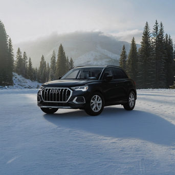 Audi Q3 equipped with winter tires parked on a snow-covered road