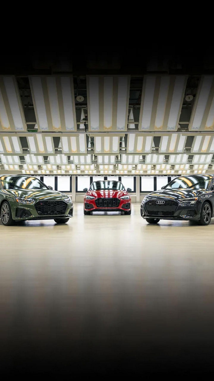Three Audi cars parked side by side in a showroom-style garage