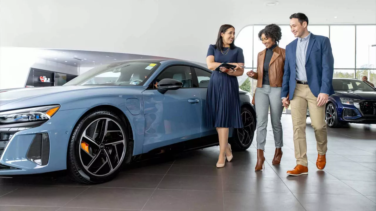 Audi employee handing a set of car keys to a customer.
