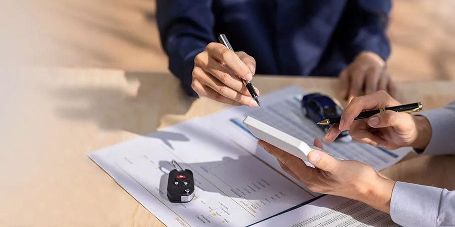 Sales representative signing papers with a customer.